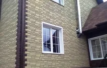 Облицювання фасаду будинку пластиковими панелями під камінь. пластиковими