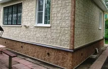 Облицювання фасаду будинку пластиковими панелями під камінь. облицювання