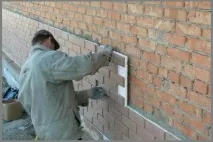 Облицювання фасаду будинку пластиковими панелями під камінь. пластиковими
