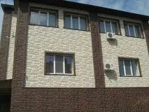 Облицювання фасаду будинку пластиковими панелями під камінь. облицювання
