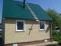 Облицювання фасаду будинку пластиковими панелями під камінь. облицювання