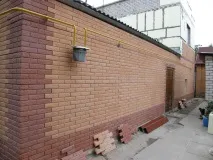 Облицювання фасаду будинку пластиковими панелями під камінь. будинку