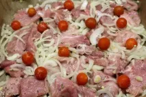Свинина запечена з цибулею, сиром та помідорами черрі. запечена