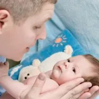 Папа доглядає за дитиною, укладає спати дитини