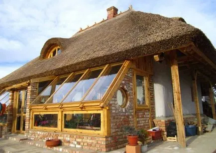 Къща от слама с сламен покрив и оранжерия