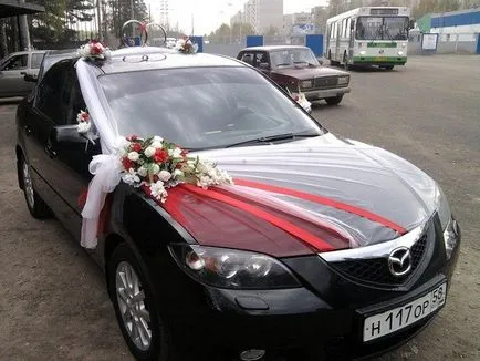 Esküvői autó díszített szalagokkal és virágokkal