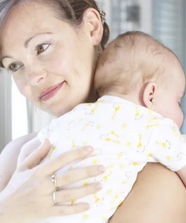 Носенето на новороденото след хранене новородено бебе
