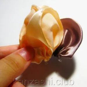 Rose de panglici de satin cu mâinile lor