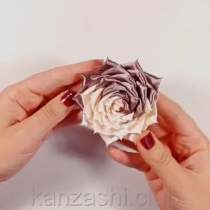 Rose de panglici de satin cu mâinile lor