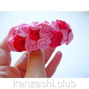 Rose de panglici de satin cu mâinile lor