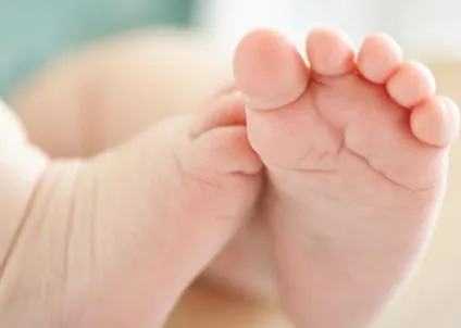 Mulaje copil se ocupă de picioare cu mâinile